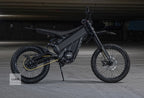 Black electric dirt bike on a concrete surface with 'LUNA' branding.